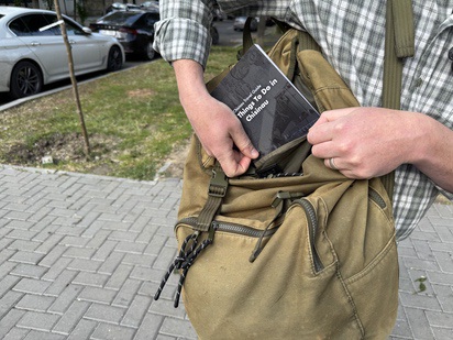 Tourists puts Chisinau City Guide in backpack
