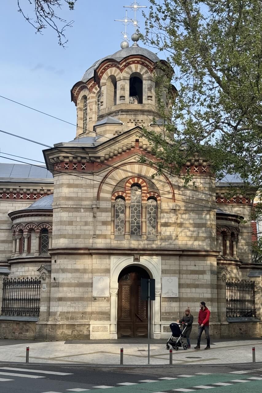 Couple with a stroller walking past St Pantaleon church in Chisinau